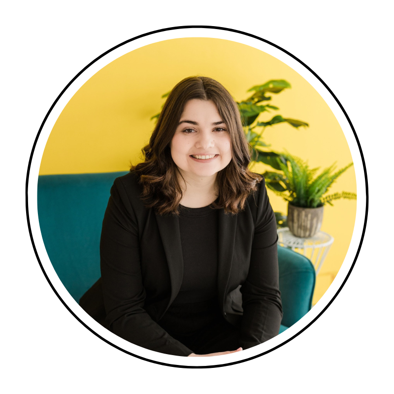 Woman with brown hair against yellow wall. 