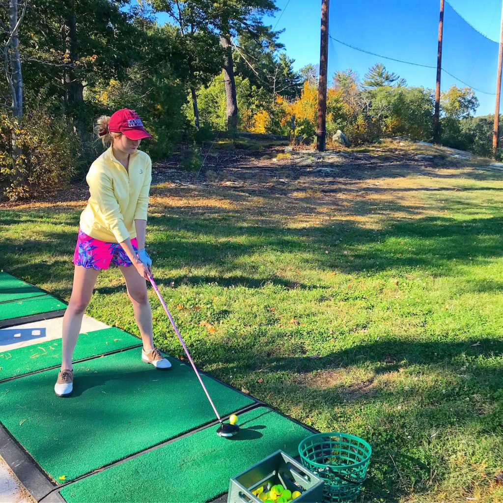 Woman practicing on driving range.