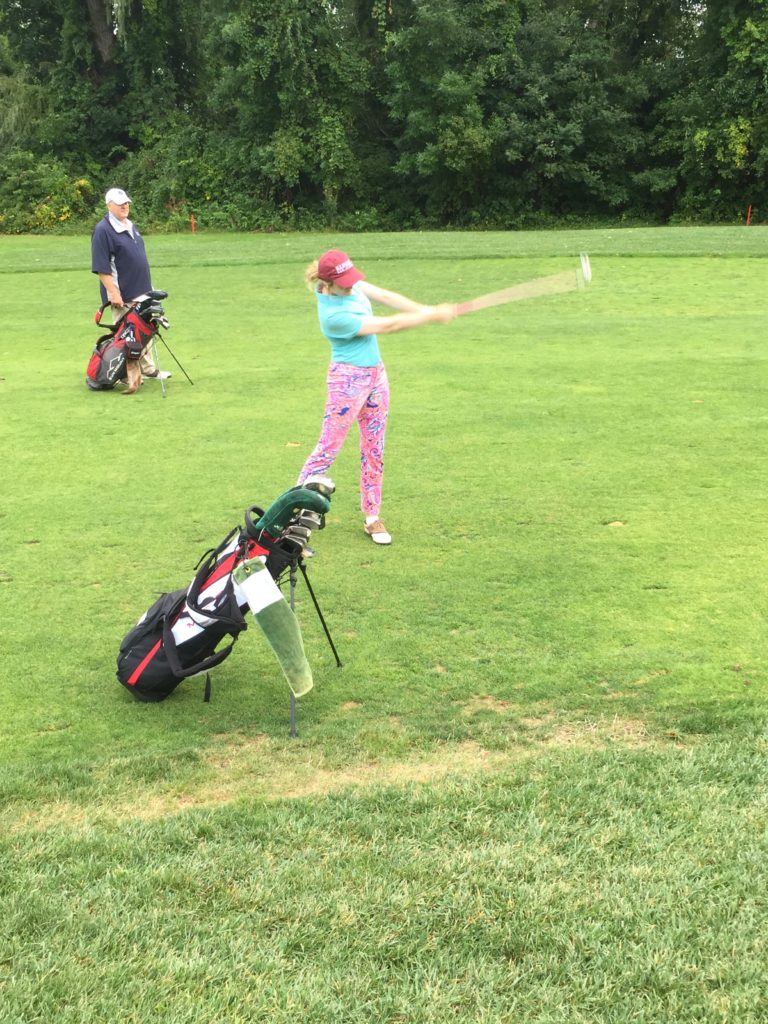 Person hitting a golf ball.