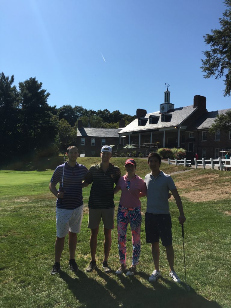 People posing on golf course.