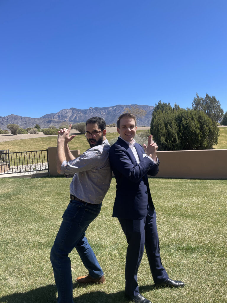 Two men stand back to back. 